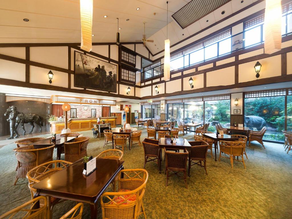un restaurant avec des tables et des chaises dans une salle dans l'établissement Awara Onsen hot spring Koubou Gurabaatei, à Awara