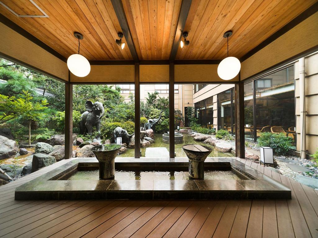 Un bâtiment avec une fontaine et une statue au milieu dans l'établissement Awara Onsen hot spring Koubou Gurabaatei, à Awara