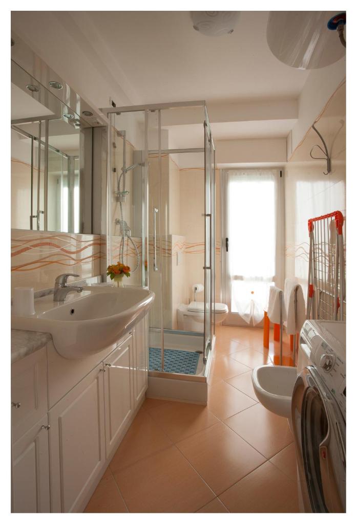 une salle de bain avec deux lavabos et une douche en verre dans l'établissement Casavacanze Internazionale, à Diano Marina