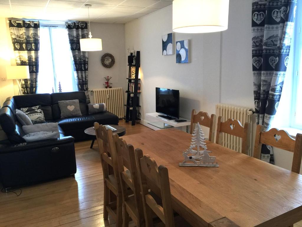 un salon avec une table en bois et un canapé dans l'établissement Le Chamois, à Gérardmer