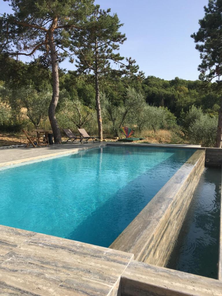 une piscine avec de l'eau bleue et des arbres dans l'établissement Villa Marghi, à Magione