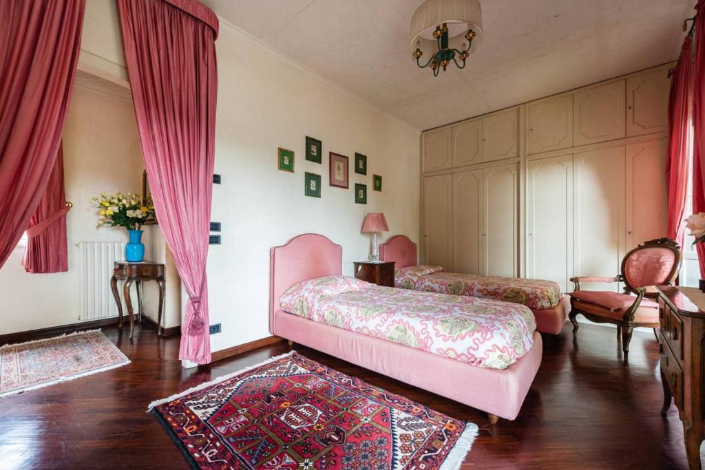 une chambre avec deux lits et une table et des chaises dans l'établissement Villa Bianca, à Lucques 23 autres photos