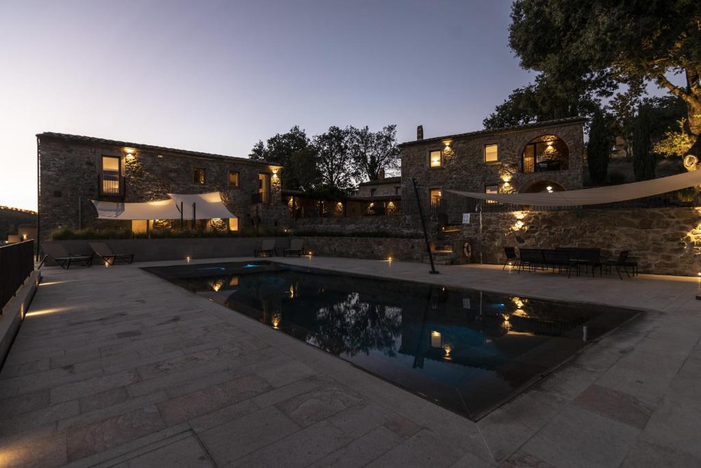 - une piscine en face d'un bâtiment avec une maison dans l'établissement Azienda Meleta, à Roccatederighi