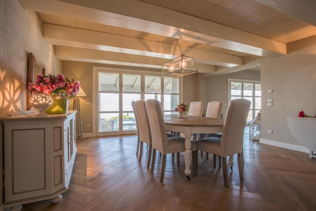 une salle à manger avec une table et des chaises en bois dans l'établissement Bianca la Luna amazing villa lakeside view, à Magione