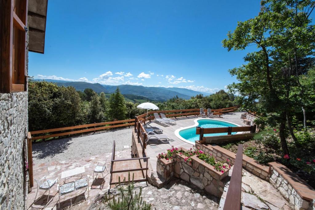 un complexe avec une piscine et des montagnes en arrière-plan dans l'établissement VillaSubasioRelax, à Spello