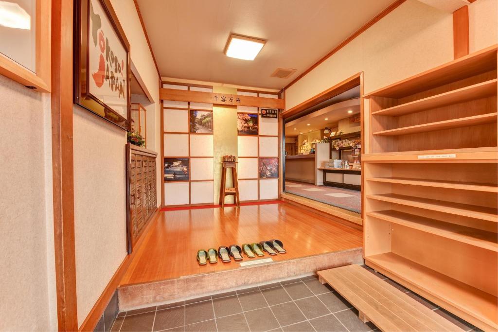 un couloir avec une chambre avec des chaussures à l'étage dans l'établissement Hidatakayama Futarishizuka Hakuun, à Takayama
