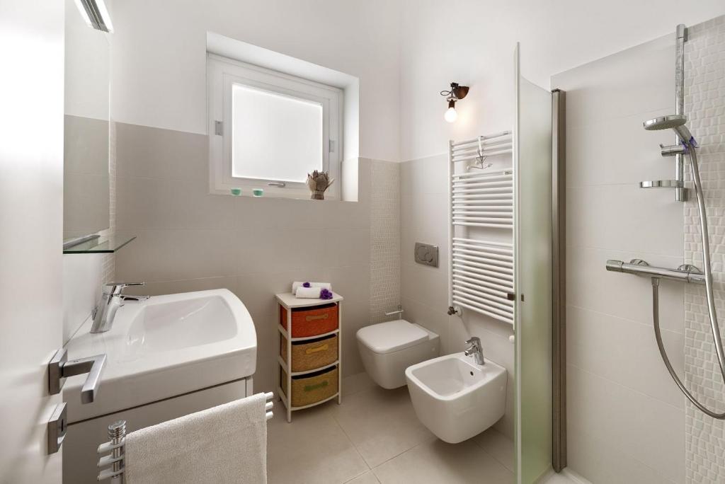 une salle de bain blanche avec un lavabo et des toilettes dans l'établissement Villa Pietrabianca, à Scicli