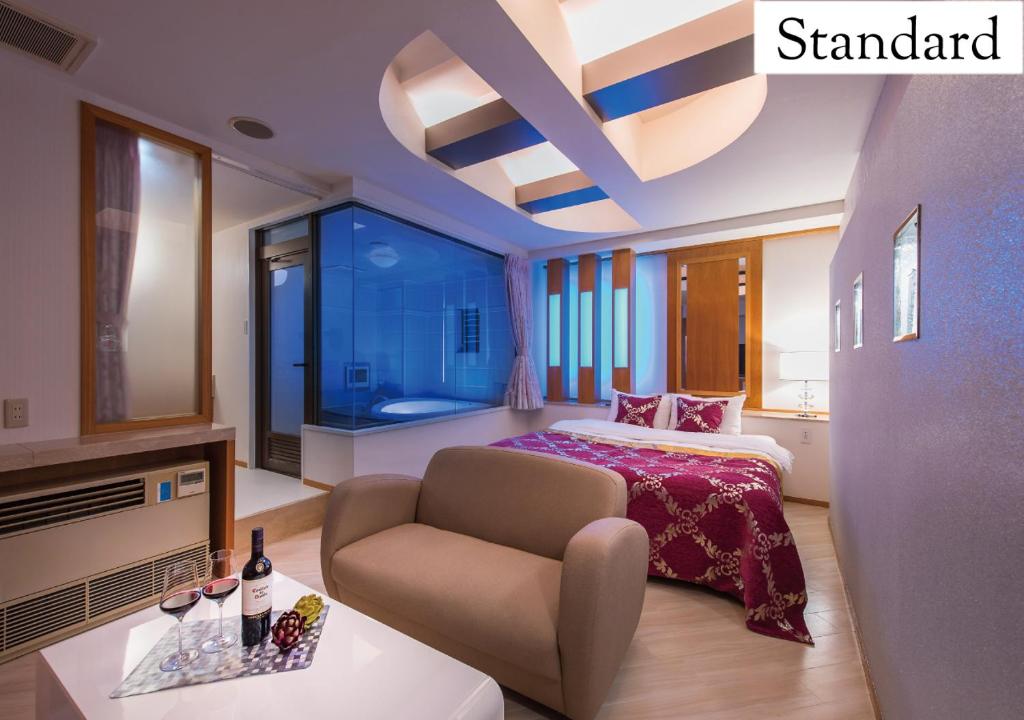 une chambre avec un lit et une chaise dans une pièce dans l'établissement Hotel New York (Adult Only), à Tokyo