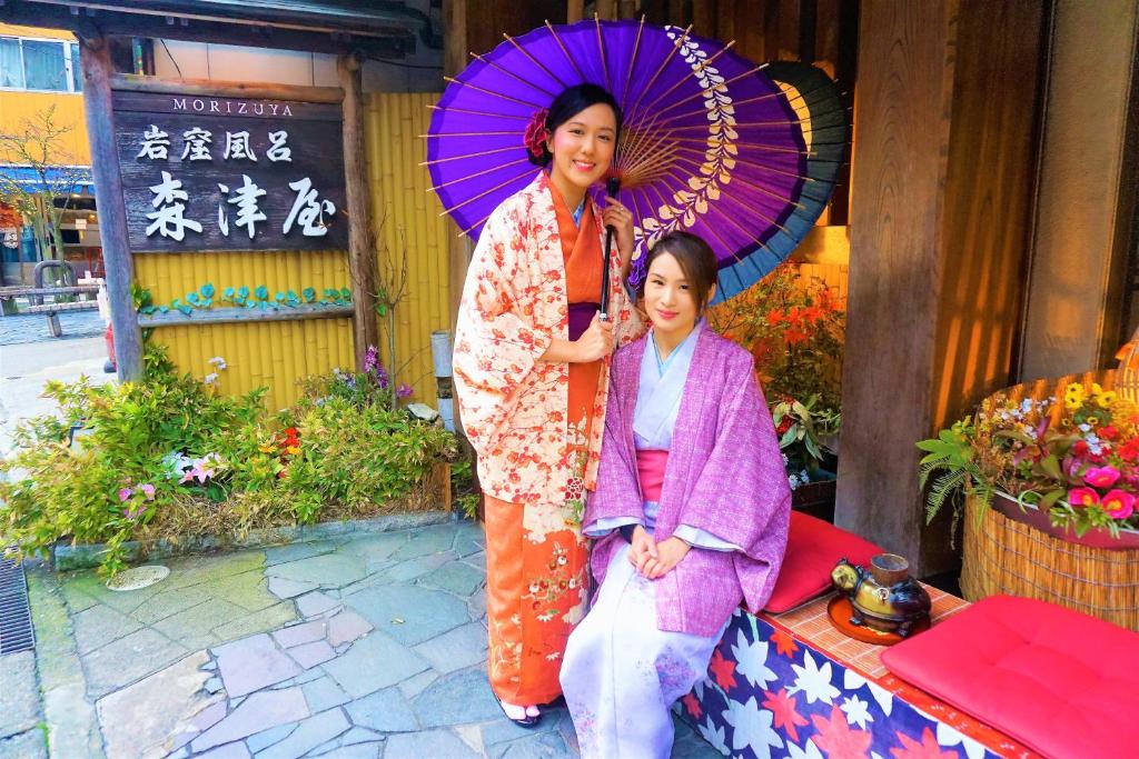 une femme debout à côté d'une fille avec un parapluie dans l'établissement Morizuya, à Toyooka