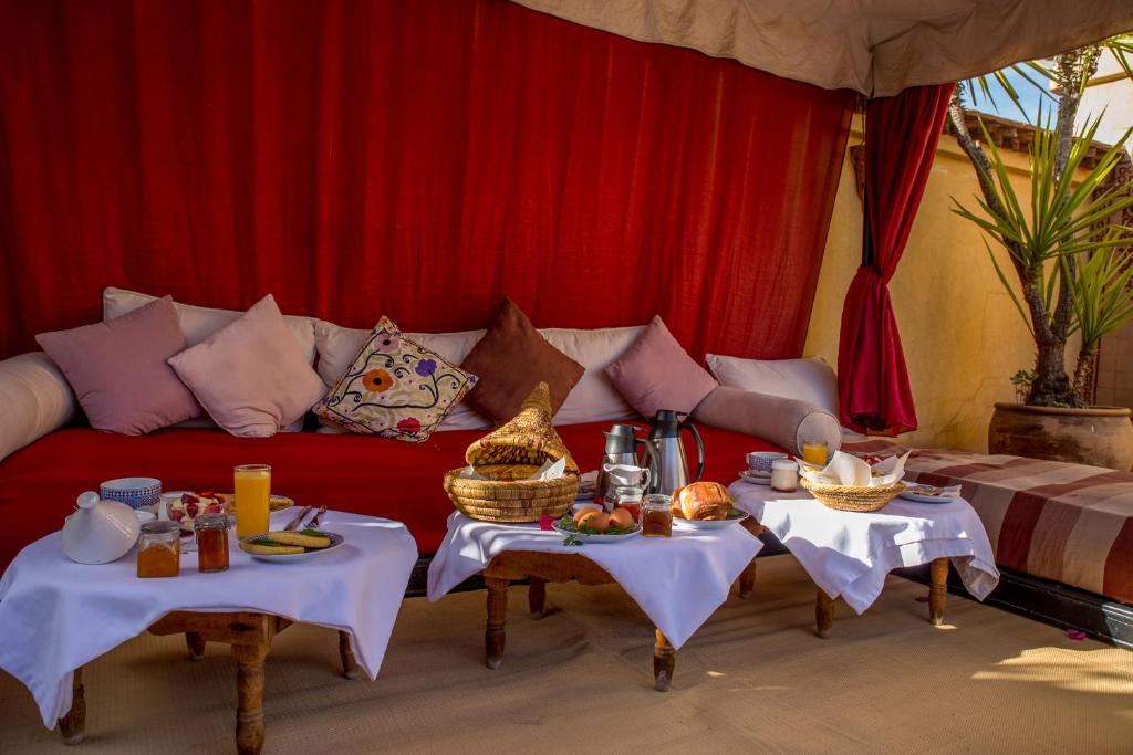 - un salon avec un canapé rouge et 2 tables dans l'établissement Riad Samsli, à Marrakech