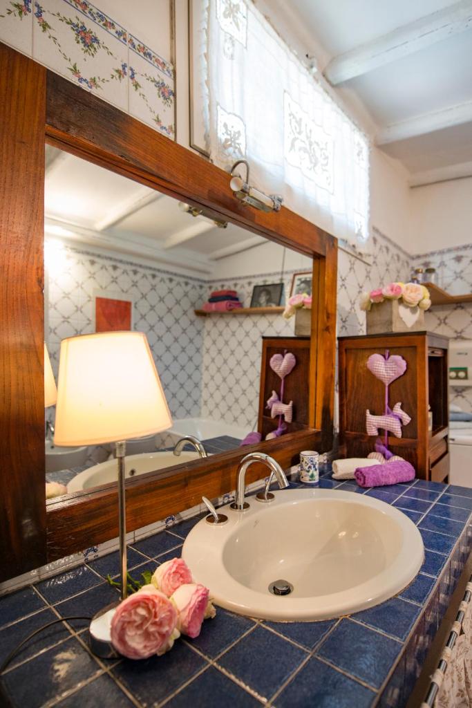 une salle de bain avec un lavabo et un miroir dans l'établissement Villa Annetta, à Poggi