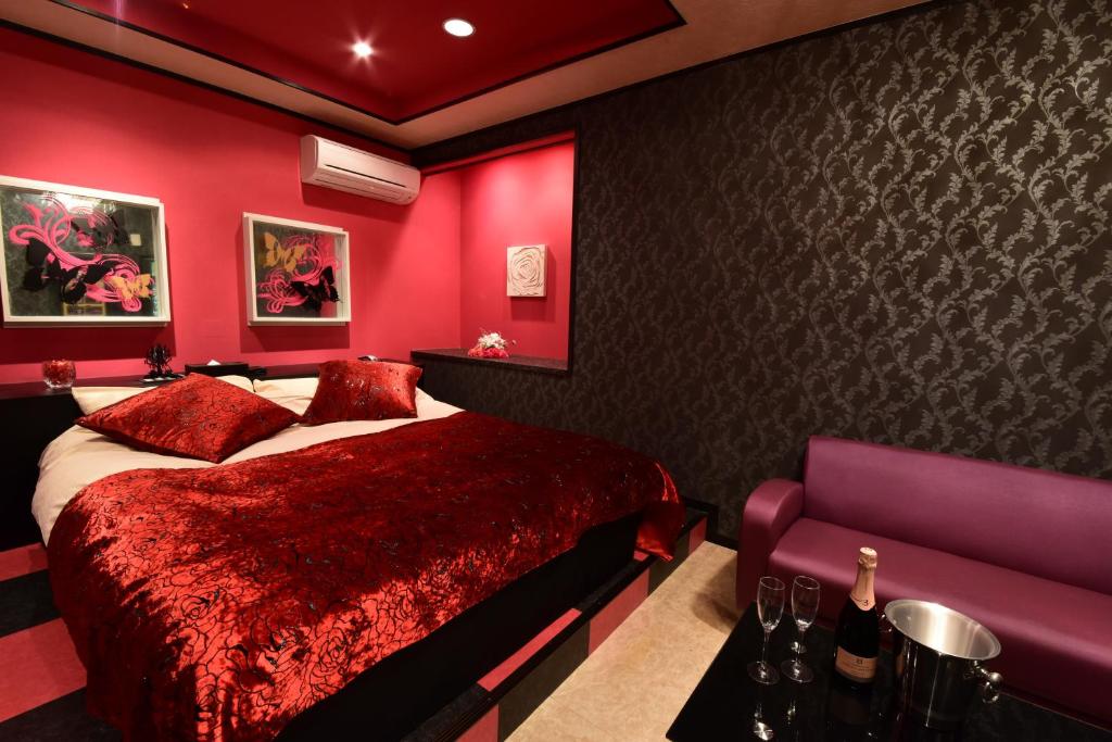 une chambre rouge avec un lit et un canapé dans l'établissement Restay Koakuma (Adult Only), à Utsunomiya