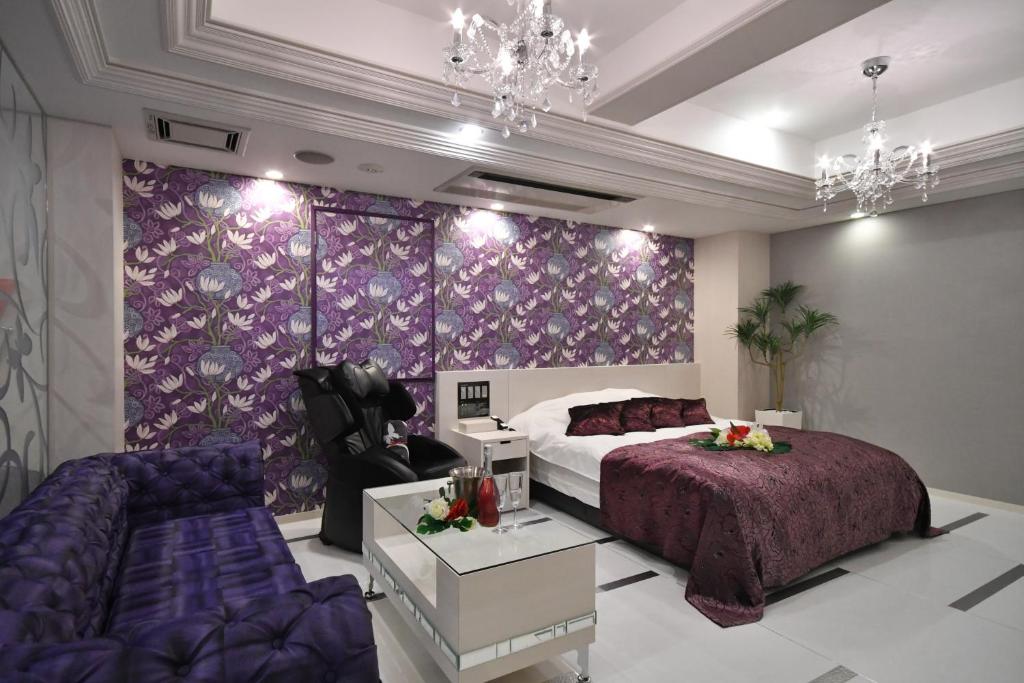 une chambre avec un lit violet et un canapé dans l'établissement Hotel agehA cinq boutique (Adult Only), à Okayama