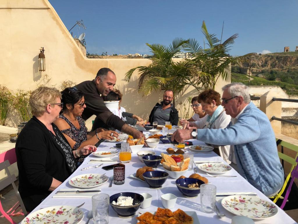 un groupe de personnes assises autour d'une table en train de manger dans l'établissement La Maison Maure, à Fès