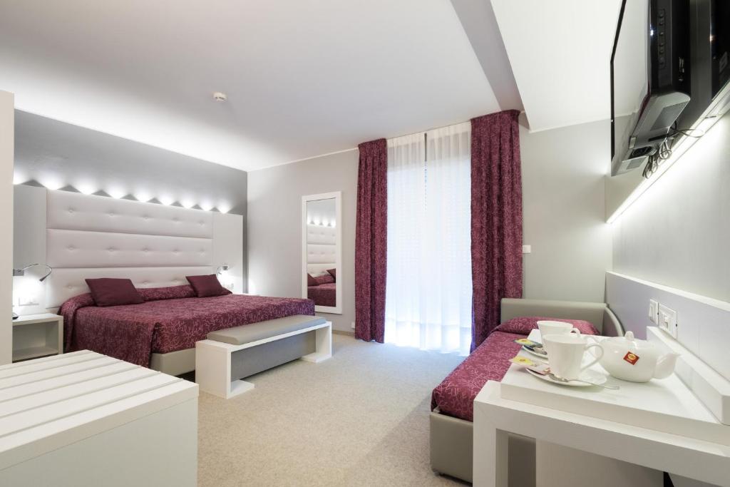 une chambre d'hôtel avec deux lits et une table dans l'établissement Hotel Al Cigno, à Lignano Sabbiadoro 122 autres photos