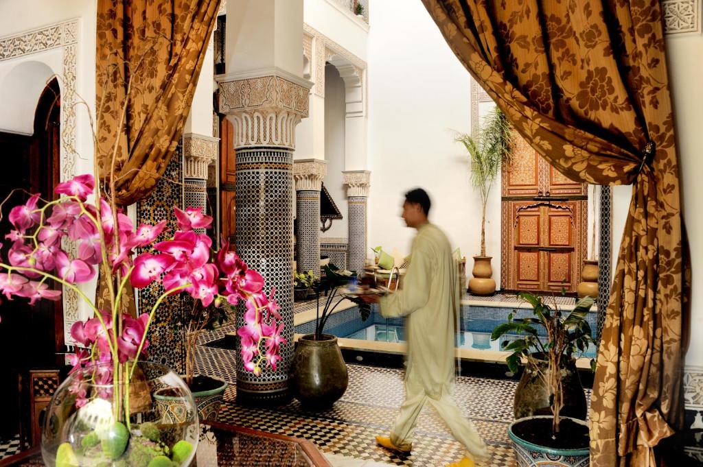 Un homme debout dans une pièce avec des plantes et des fleurs dans l'établissement Riad El Amine Fès - Historic Hotels Worldwide, à Fès 37 autres photos