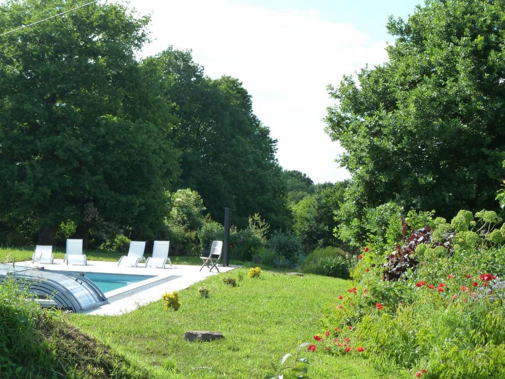 une piscine avec des chaises longues dans un jardin dans l'établissement Gîte Le Logis de l'Etang de l'Aune, à Iffendic