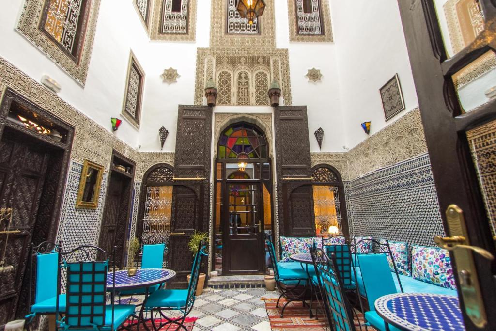 une chambre avec des chaises et des tables bleues dans un bâtiment dans l'établissement Riad Hala, à Fès