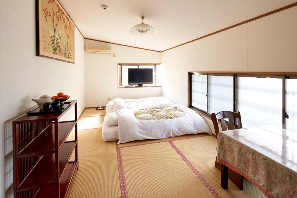 Cette chambre comprend un lit et une télévision. dans l'établissement Hotobil B&B 潤 An inn that enjoys breakfast, à Nara