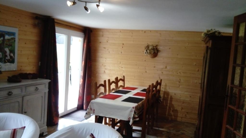 une salle à manger avec une table et des chaises et une fenêtre dans l'établissement Le TETRAS, à Lamoura