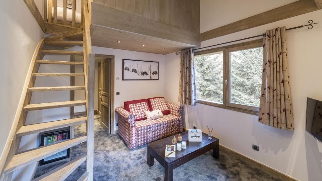 - un salon avec un escalier, un canapé et une table dans l'établissement Hotel La Chaudanne, à Méribel
