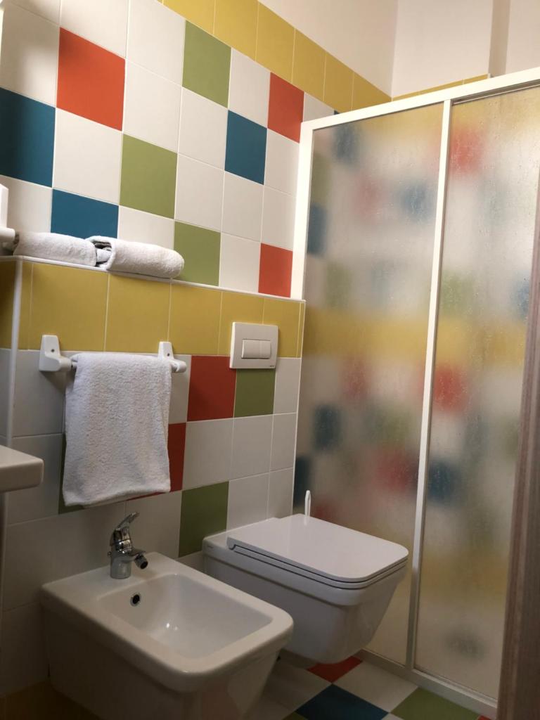 une salle de bain avec toilettes et lavabo dans l'établissement Hotel Karibe, à Bibione