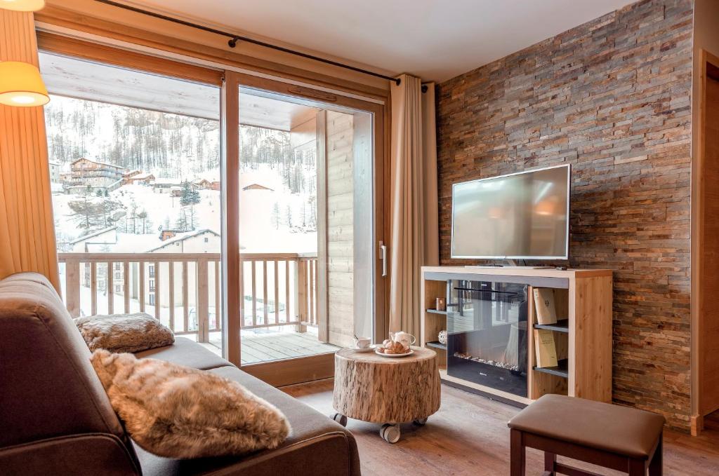un salon avec un canapé et une télévision dans l'établissement Résidence Club MMV L'Altaviva, à Tignes