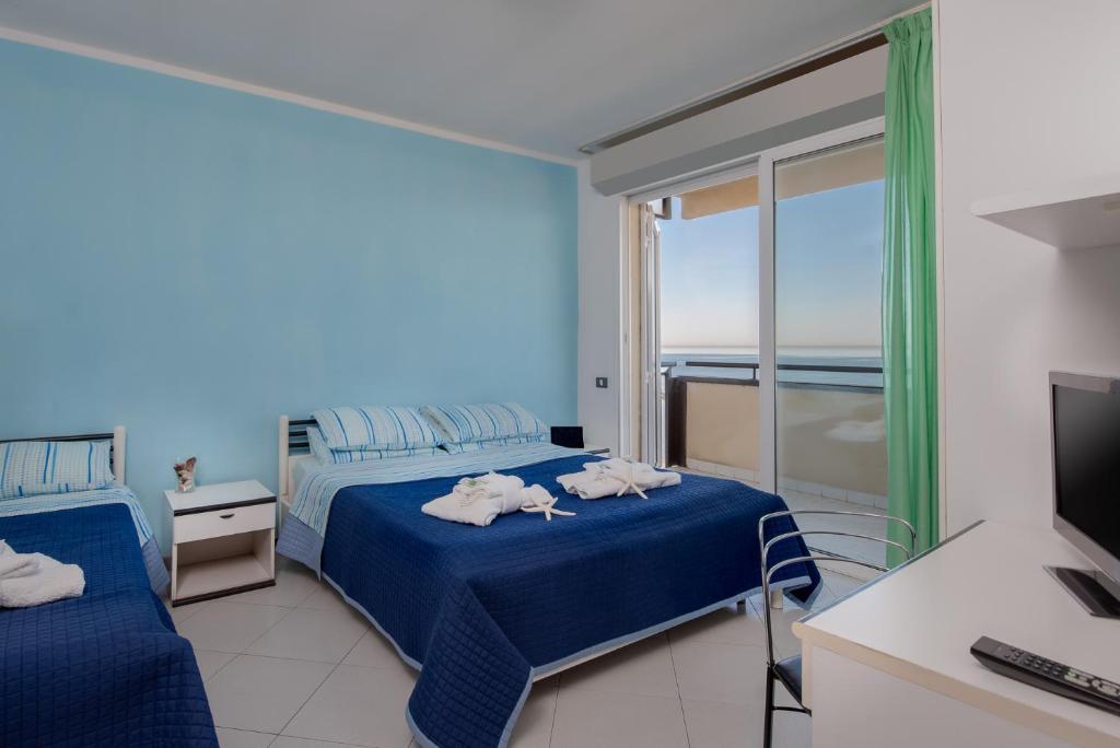 une chambre d'hôtel avec deux lits et une télévision dans l'établissement Residence Belvedere Vista - SeaFront, à Rimini 41 autres photos