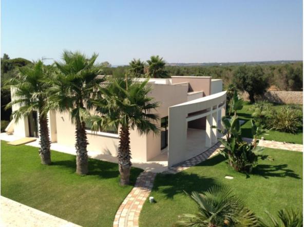 une maison avec des palmiers devant dans l'établissement La Casa di Flò Luxury Rooms, à Alezio