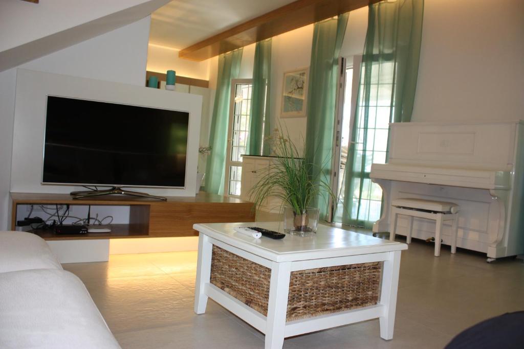 - un salon avec un canapé, une télévision et un piano dans l'établissement Villa Torre San Giovanni Ugento, à Torre San Giovanni