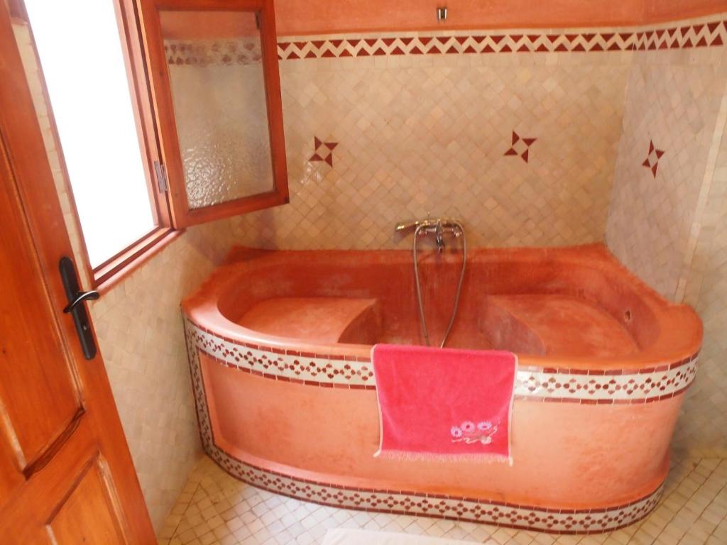La salle de bains est pourvue d'une baignoire et d'un miroir. dans l'établissement Riad Al khansaa, à Essaouira