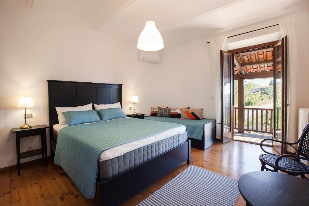 une chambre avec un grand lit et un balcon dans l'établissement Villa Vinory - La Mandragola, à Mombercelli