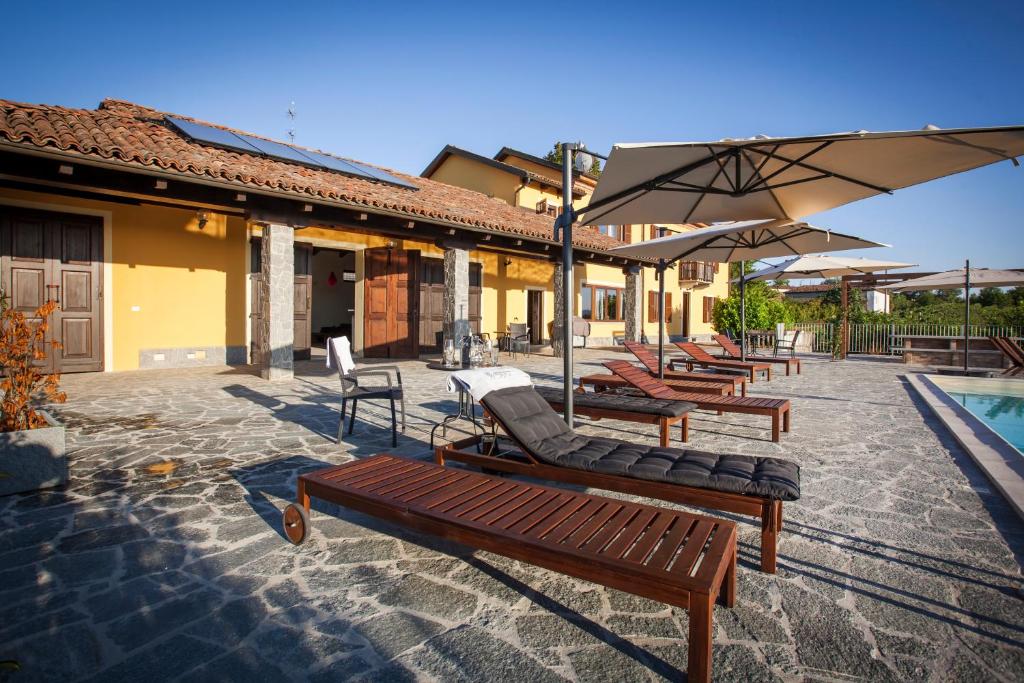 - une rangée de chaises longues et de parasols à côté de la piscine dans l'établissement Villa Vinory - La Mandragola, à Mombercelli
