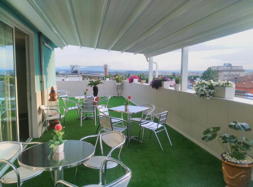 un patio avec tables et chaises sur un balcon dans l'établissement Hotel Aurora Mare, à Rimini
