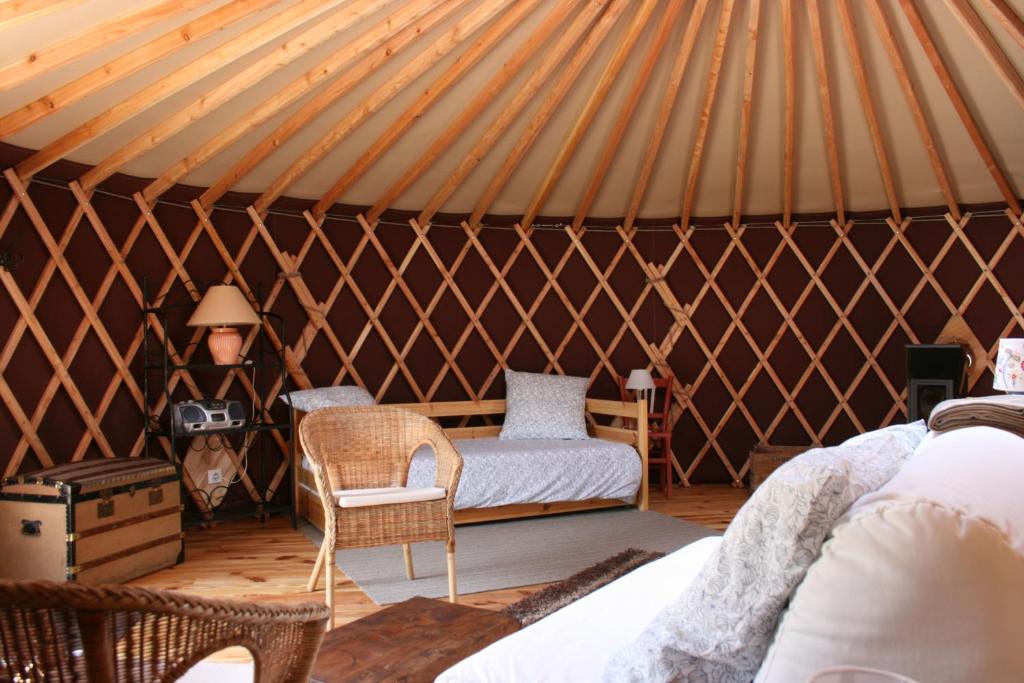 une chambre avec une yourte avec un lit et une chaise dans l'établissement Yourtes en Terrasse, à Bonneval