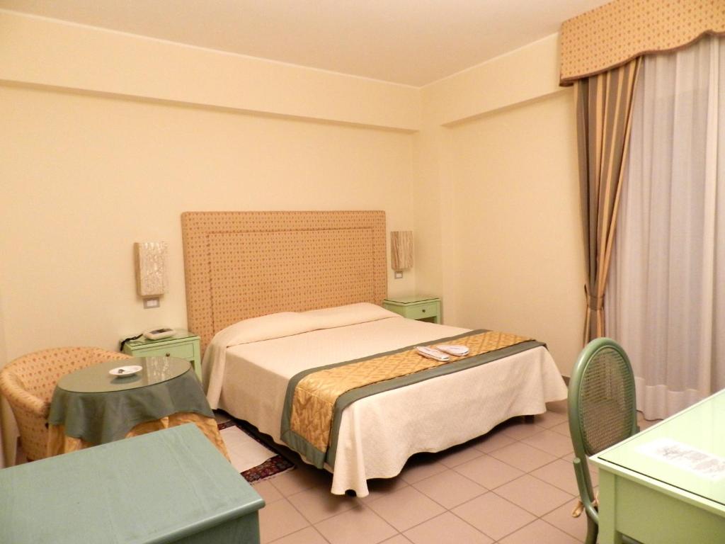 une petite chambre avec un lit et une table dans l'établissement Hotel Il Mulino, à Capo dʼOrlando