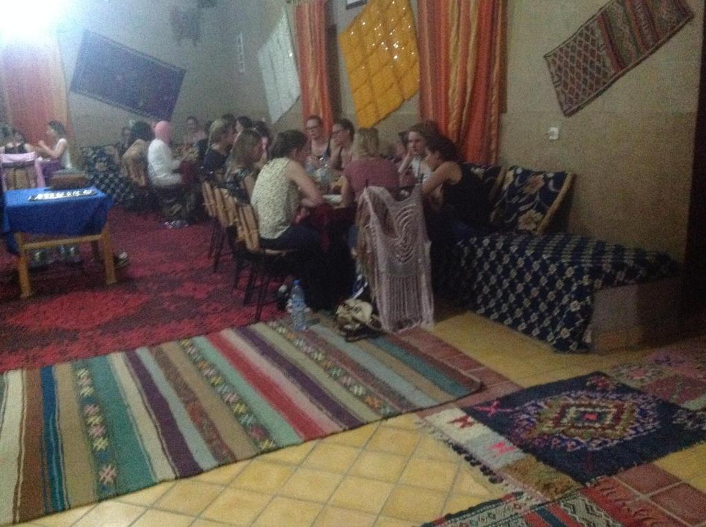 un groupe de personnes assises à une table dans une pièce dans l'établissement Hôtel Riad Tadarte Familier, à Merzouga 37 autres photos