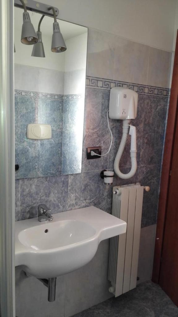 une salle de bain avec un lavabo et un miroir dans l'établissement Hotel Esperia, à Piombino 20 autres photos