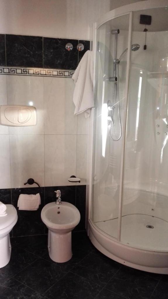 une salle de bain avec douche, lavabo et toilettes dans l'établissement Hotel Esperia, à Piombino