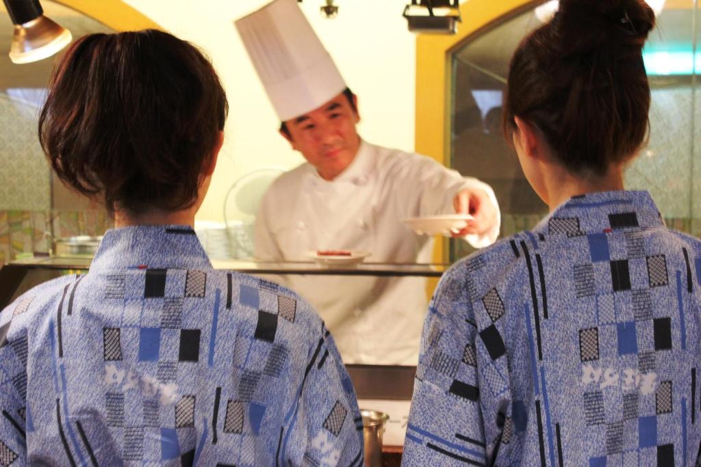 - deux personnes debout dans une cuisine en regardant un chef dans l'établissement Hotel Mahoroba, à Noboribetsu 37 autres photos