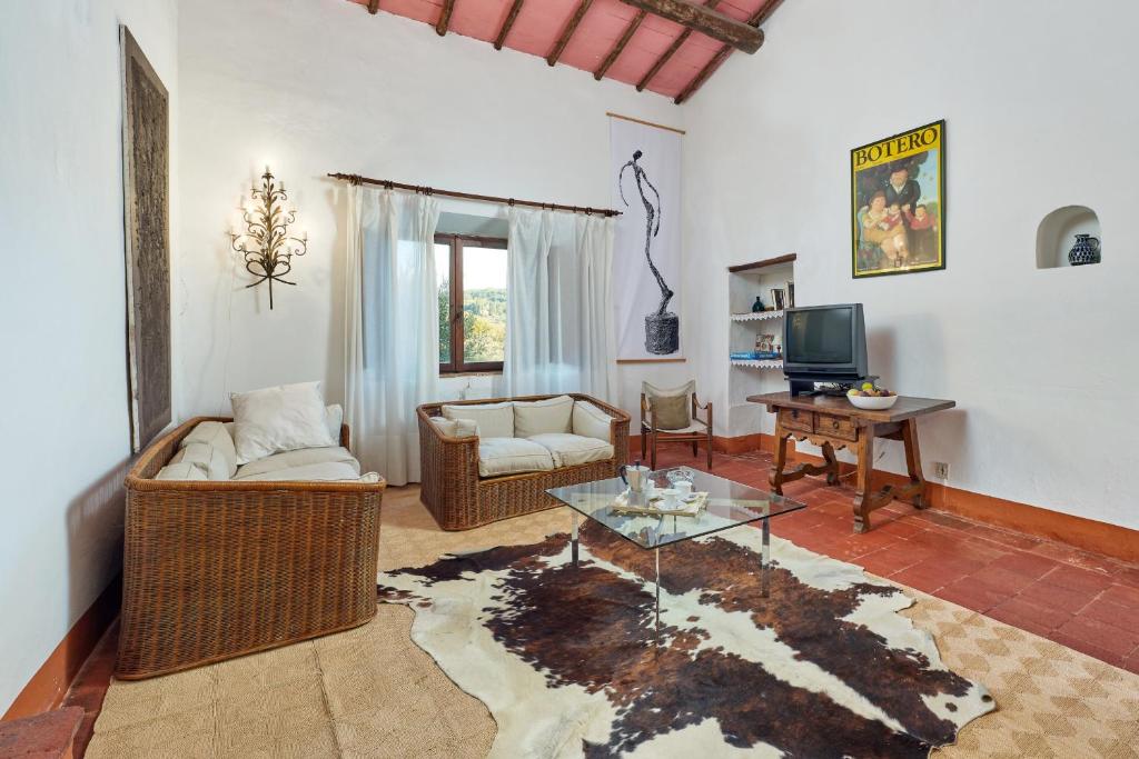 un salon avec un canapé et une table dans l'établissement Casale Sandonatino by VacaVilla, à Castellina in Chianti