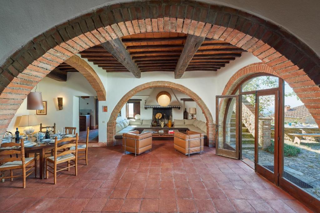 - un salon avec une voûte, une table et des chaises dans l'établissement Casale Sandonatino by VacaVilla, à Castellina in Chianti