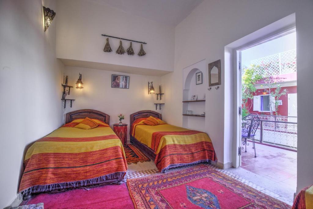 deux lits dans une chambre avec balcon dans l'établissement Riad Marhbabikoum, à Marrakech