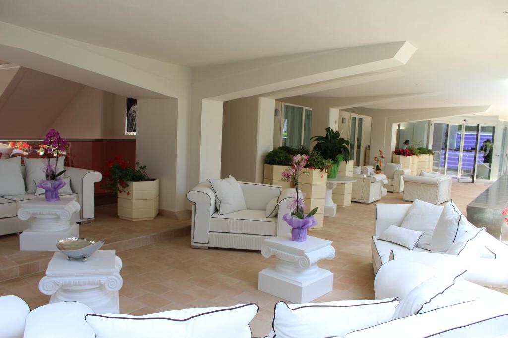 un grand salon avec des canapés blancs et des plantes dans l'établissement Boutique Hotel Paradiso Bovelacci, à Milano Marittima 121 autres photos