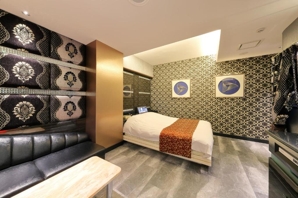 une chambre avec un lit et un banc dans l'établissement Hotel Cherena Kunitachi (Adult Only), à Kunitachi