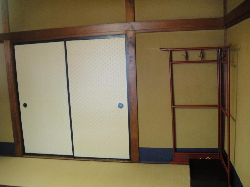 une chambre avec deux portes coulissantes et une étagère dans l'établissement Kurhaus Ishibashi Ryokan, à Shimoda