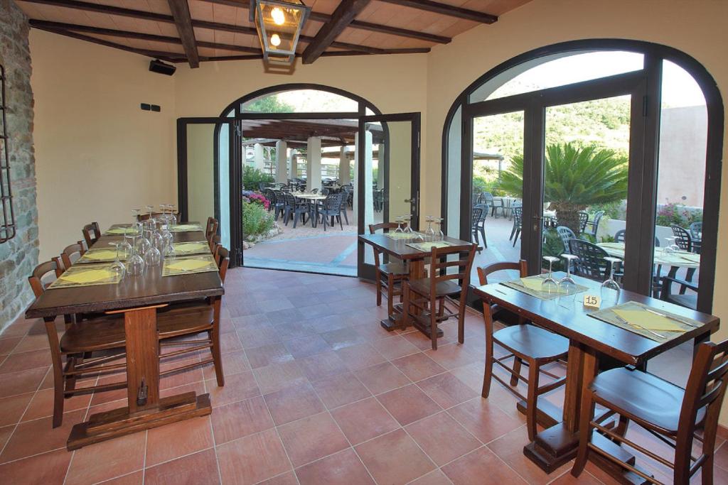 une salle à manger avec des tables et des chaises ainsi qu'une terrasse dans l'établissement Il Villaggio Di Giuele, à Finale Ligure