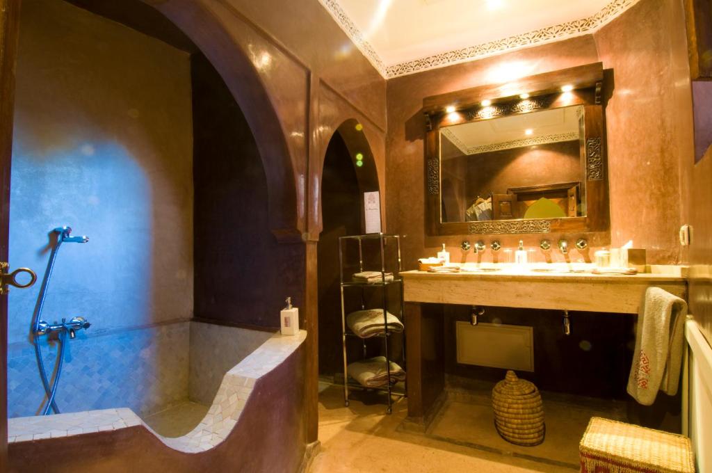 une salle de bain avec une baignoire, un lavabo et un miroir dans l'établissement Riad Charaï, à Marrakech