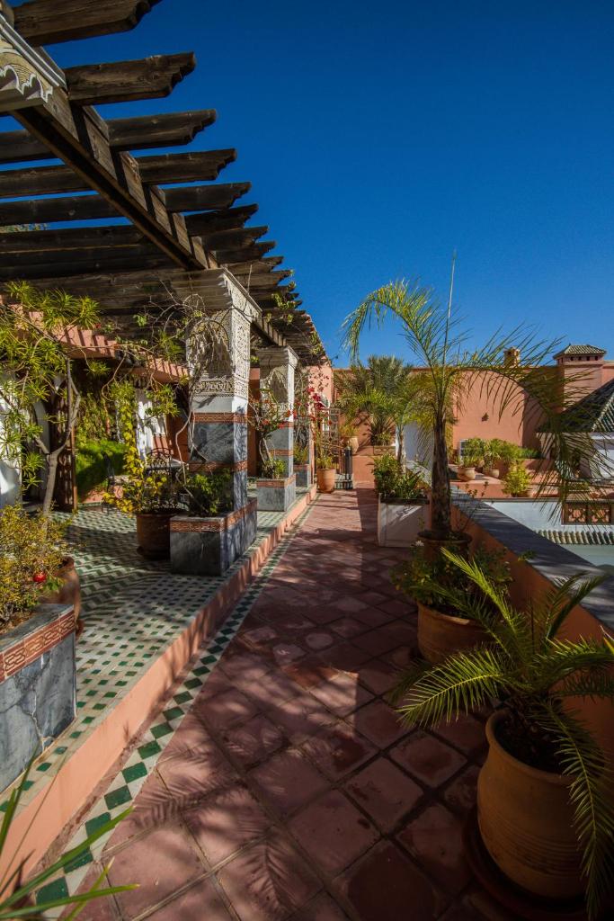 d'une terrasse avec des plantes en pot et un toit. dans l'établissement Palais Dar Donab, à Marrakech