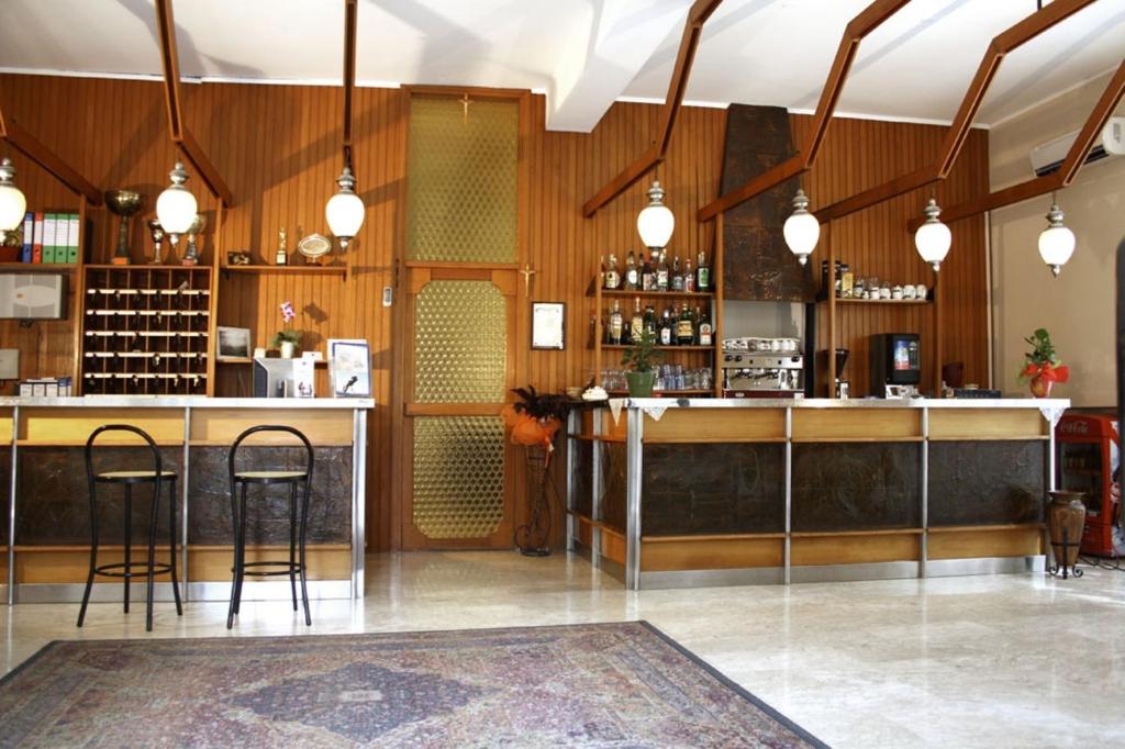 un bar avec des tabourets dans une pièce aux murs en bois dans l'établissement Hotel Blurelda, à Silvi Marina